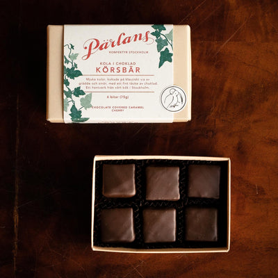 A small gift with great content and lots of love. Six pieces of soft toffee with cherries dipped in dark chocolate. A delicate craft from Pärlans Konfektyr in Stockholm.